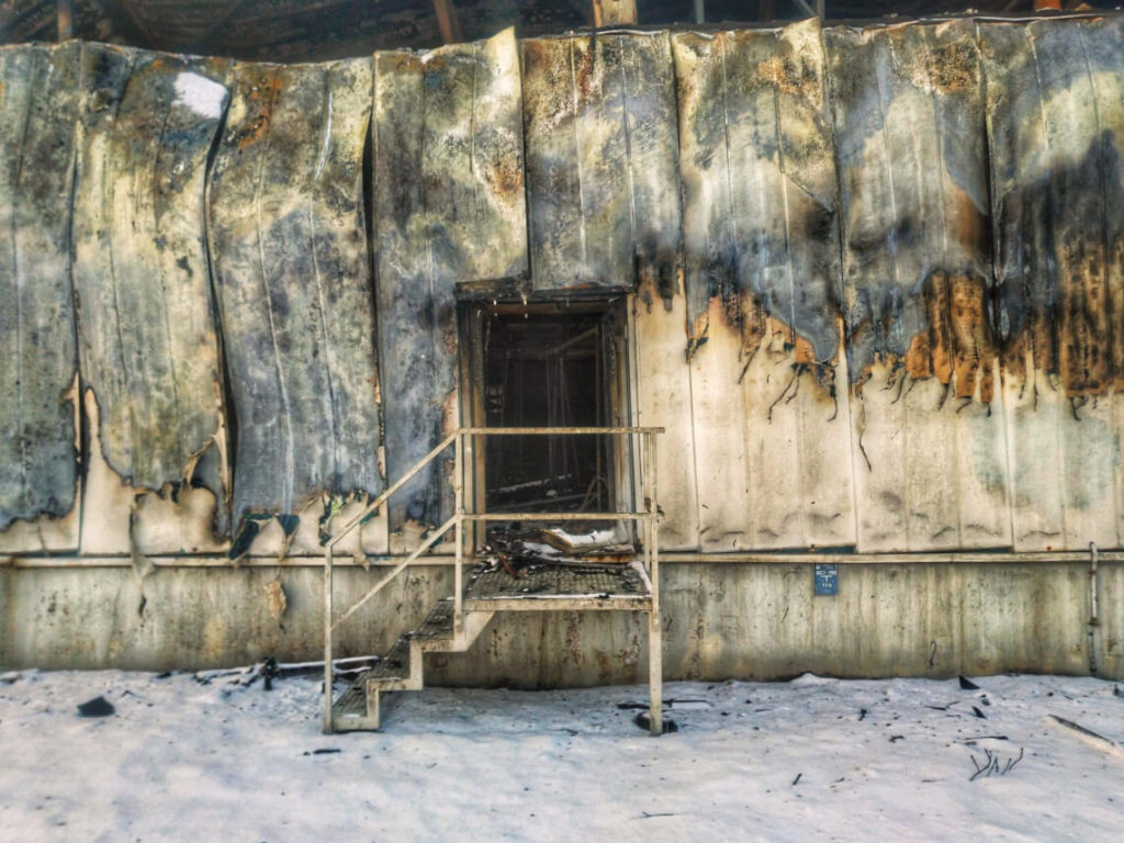 Der Eingang zu einer abgebrannten Lagerhalle